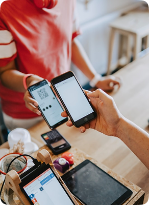 A customer paying by mobile wallet at a shop counter