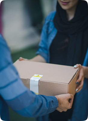 A shopkeeper handing a parcel back to a customer